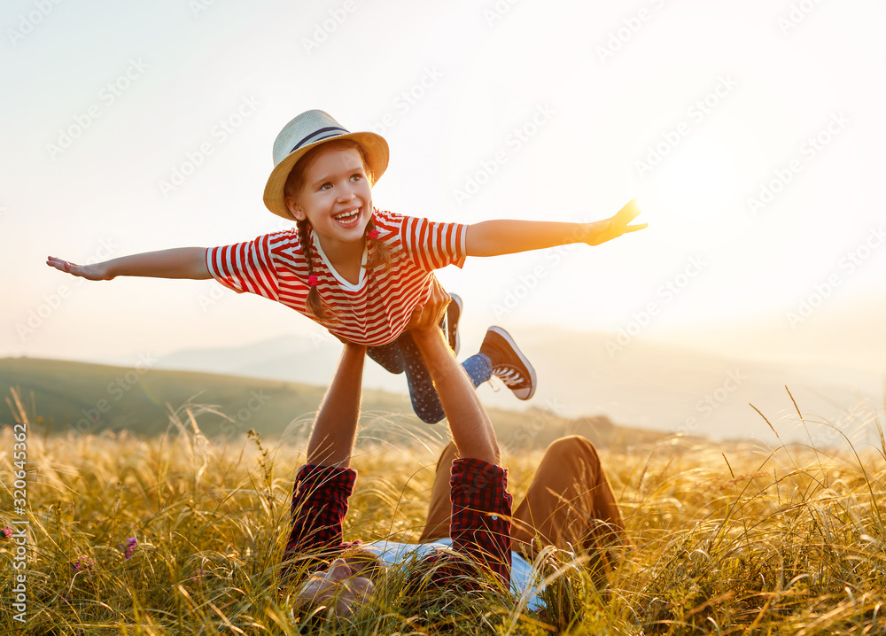 父亲节。幸福的家庭父亲和孩子的女儿在日落时在大自然中玩耍和欢笑。