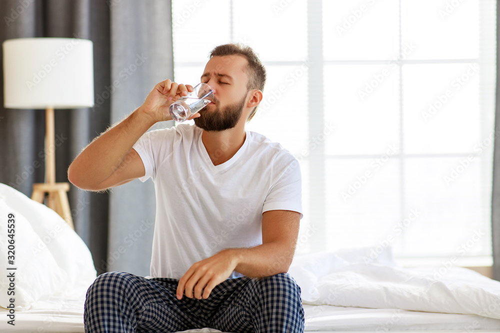 young healthy man drinking water in morning