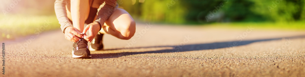 年轻女子在柏油路上的公园里跑步