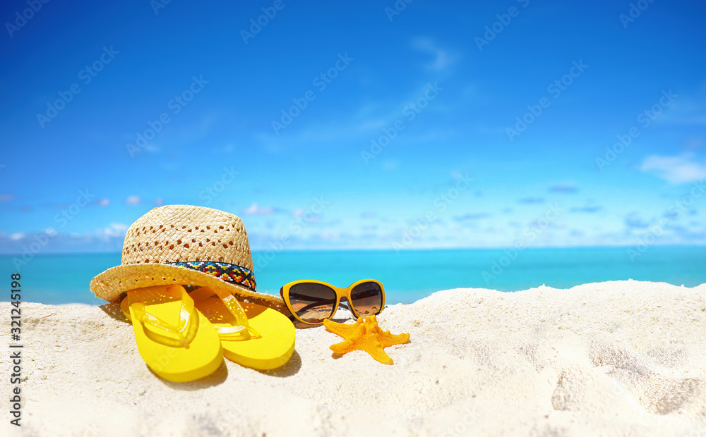 概念夏日海滩度假。海滩配饰-草帽、眼镜、海星、黄色人字拖