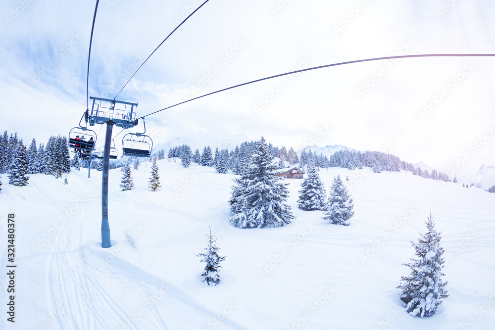 Ski lift over magnificent snow covered fir forest on Alpine mountain resort