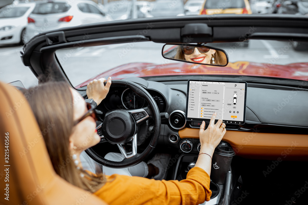 快乐的女人用数字仪表板控制汽车，在驾驶ca时切换自动驾驶模式