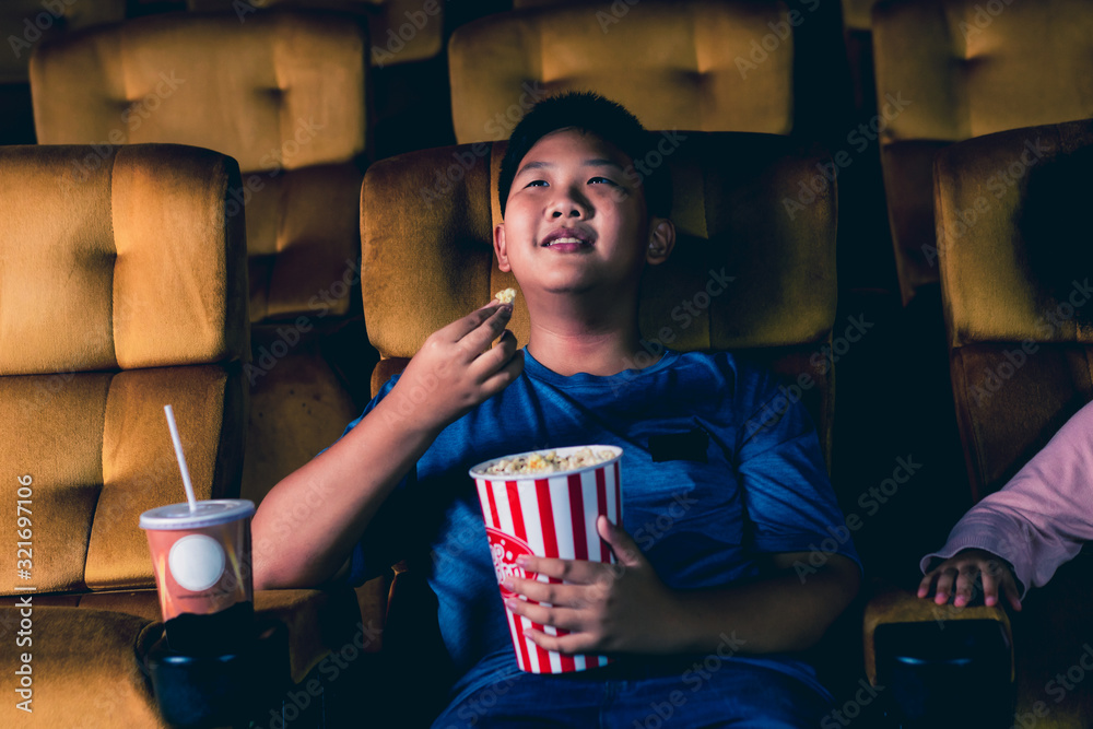Three children having fun and enjoy watching movie in cinema