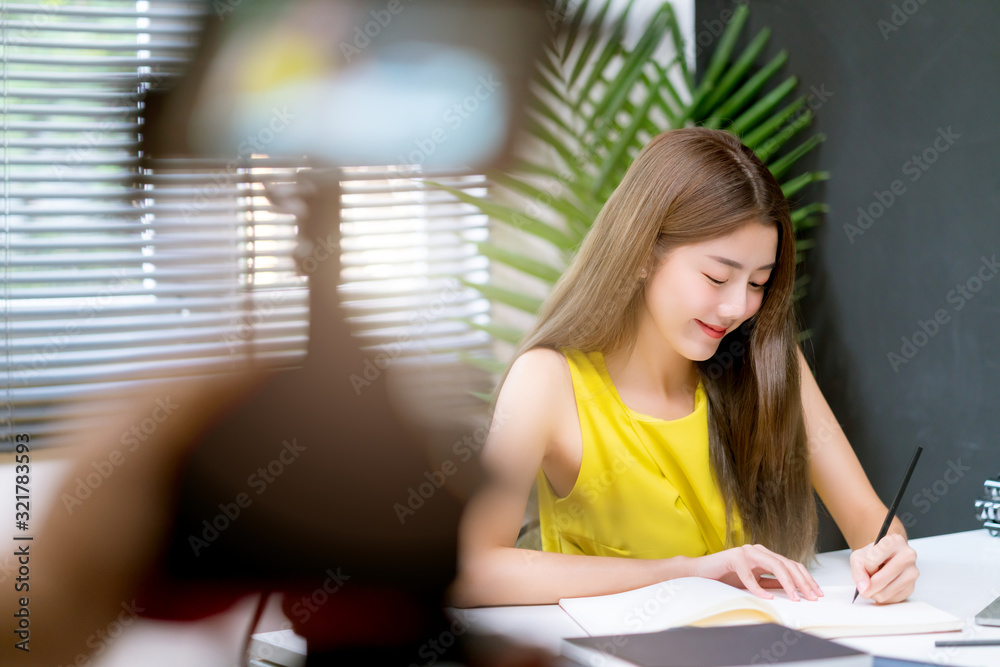 迷人的亚洲女性商务女性黄色休闲连衣裙享受笔记本电脑办公室的日常工作