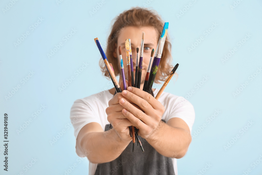 在彩色背景上使用工具的年轻男艺术家