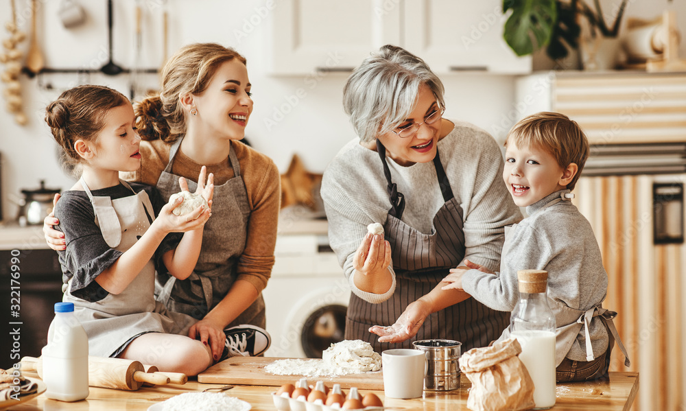 幸福的家庭一位祖母带着她的女儿和孙子在厨房做饭、揉面团、烤面包