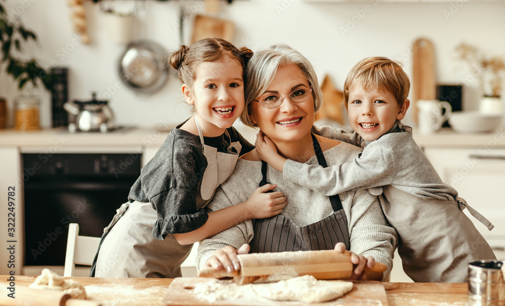 happy family grandmother and grandchildren cook in the kitchen, knead dough, bake cookies.