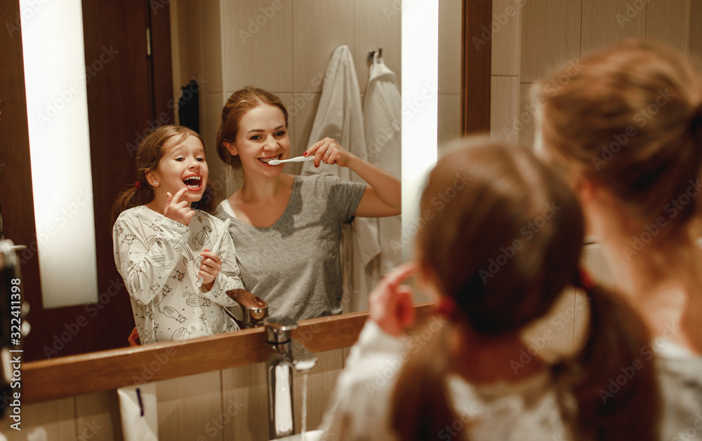 口腔健康与卫生。母亲和孩子女儿在浴室刷牙