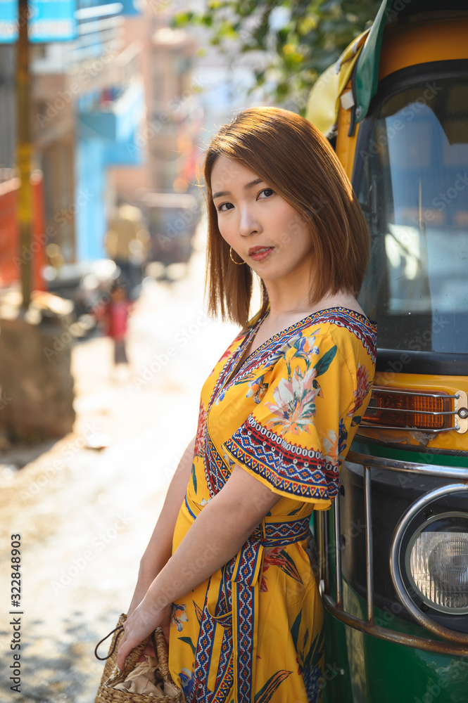 拉贾斯坦邦蓝色城市焦特布尔，一名年轻女子站在Tuktuk印度出租车旁的画像，