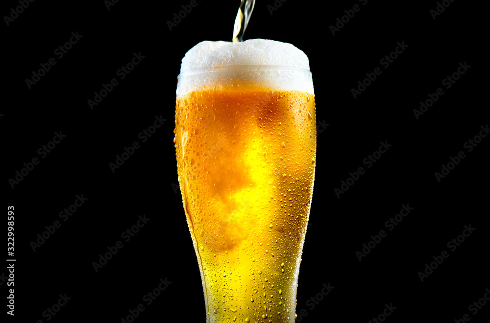 啤酒。冷精酿淡啤酒倒入装有水滴的玻璃杯中。一品脱啤酒被隔离