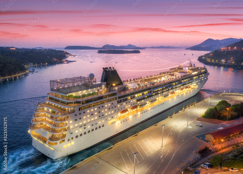 Aerial view of cruise ship in port at night in Dubrovnik. Ships and boats with illumination in harbo