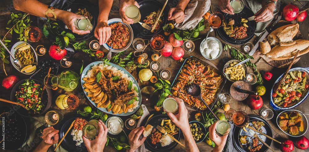 一家人在乡村餐桌上用土耳其菜羊排、木瓜、青豆庆祝