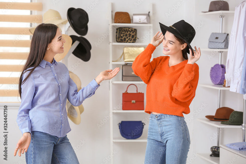 年轻女性在现代商店选购帽子