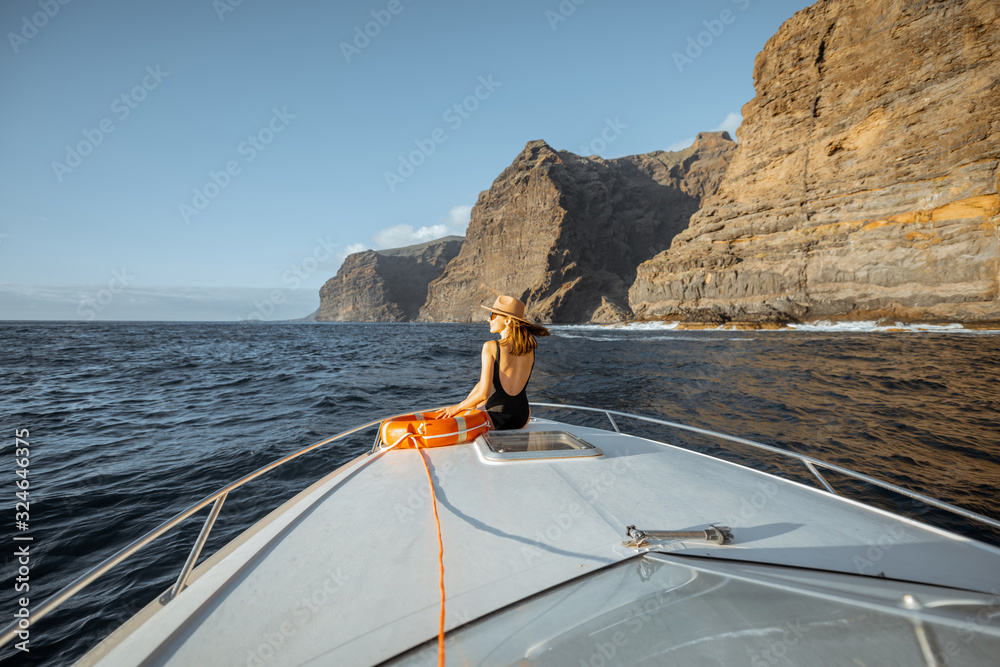一名女子在呼吸附近航行时，将救生圈放在游艇机头上，享受海上航行