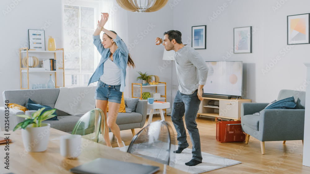 Happy Beautiful Couple is Having Fun and Actively Dancing in their Cozy Living Room at Home. They Sm