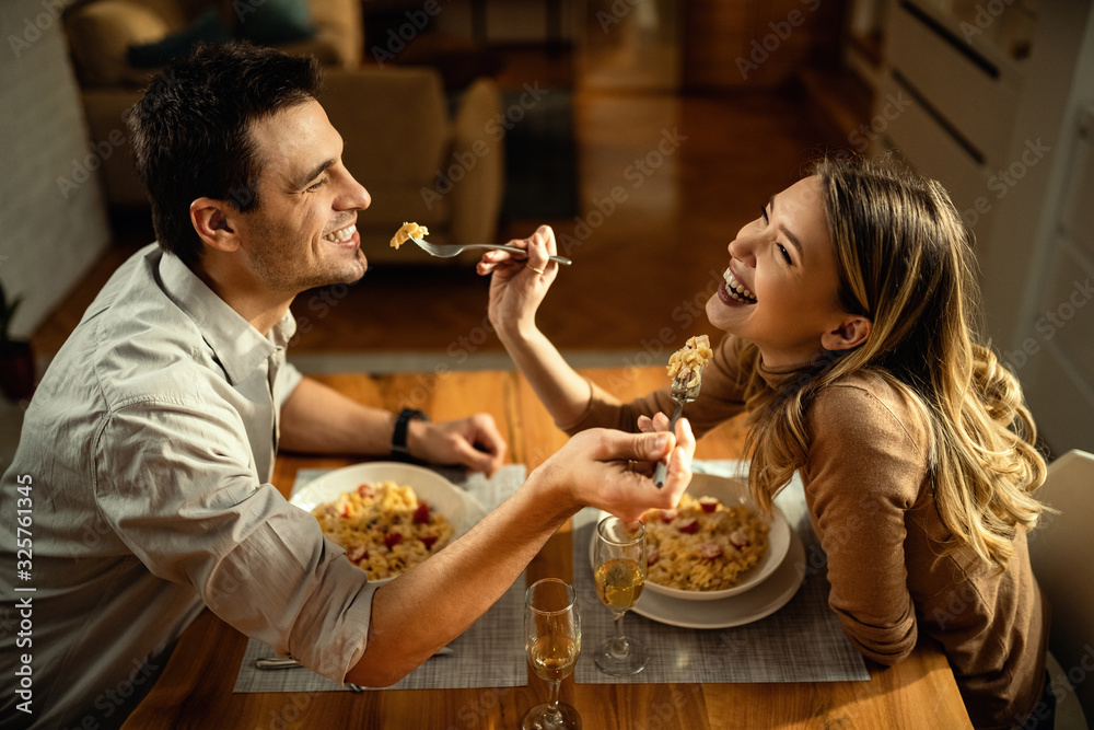 幸福的情侣在餐桌上分享美食。