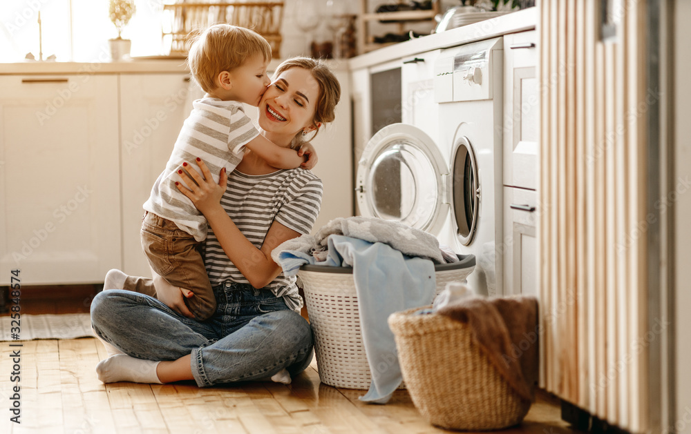 幸福家庭的母亲、家庭主妇和孩子在洗衣机里。