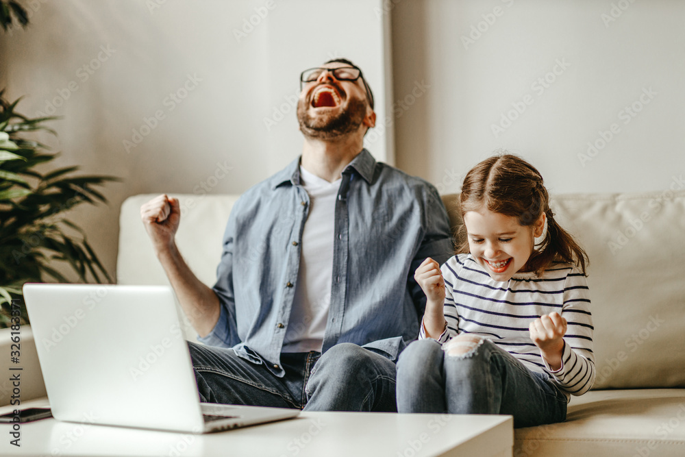 father male businessman working at a computer with child daughter, won victory, success, triumph.