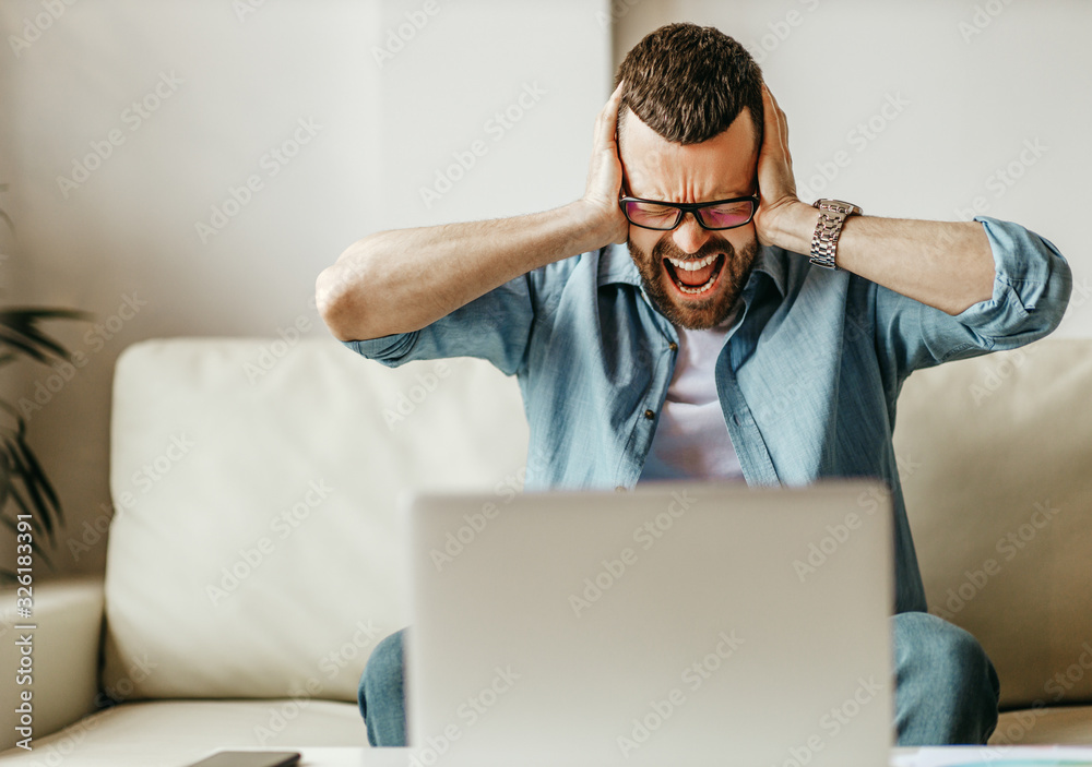 不快乐、疲惫的商人在家办公，在电脑上工作，压力很大。
