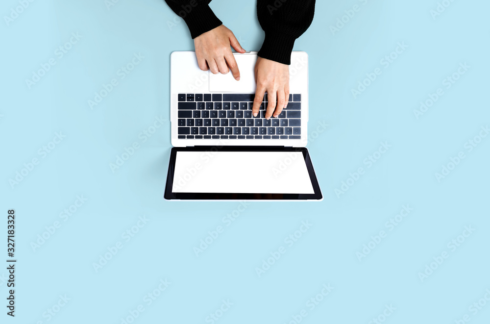 在纯色背景下使用笔记本电脑的人