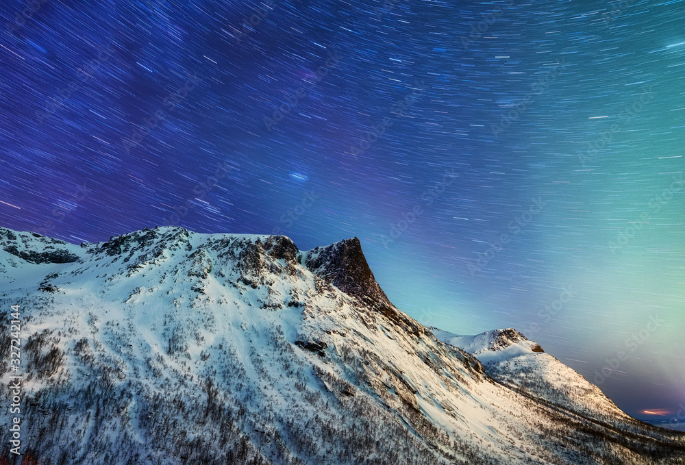 挪威森贾岛的山脉和星空。星途和高峰。冬季景观