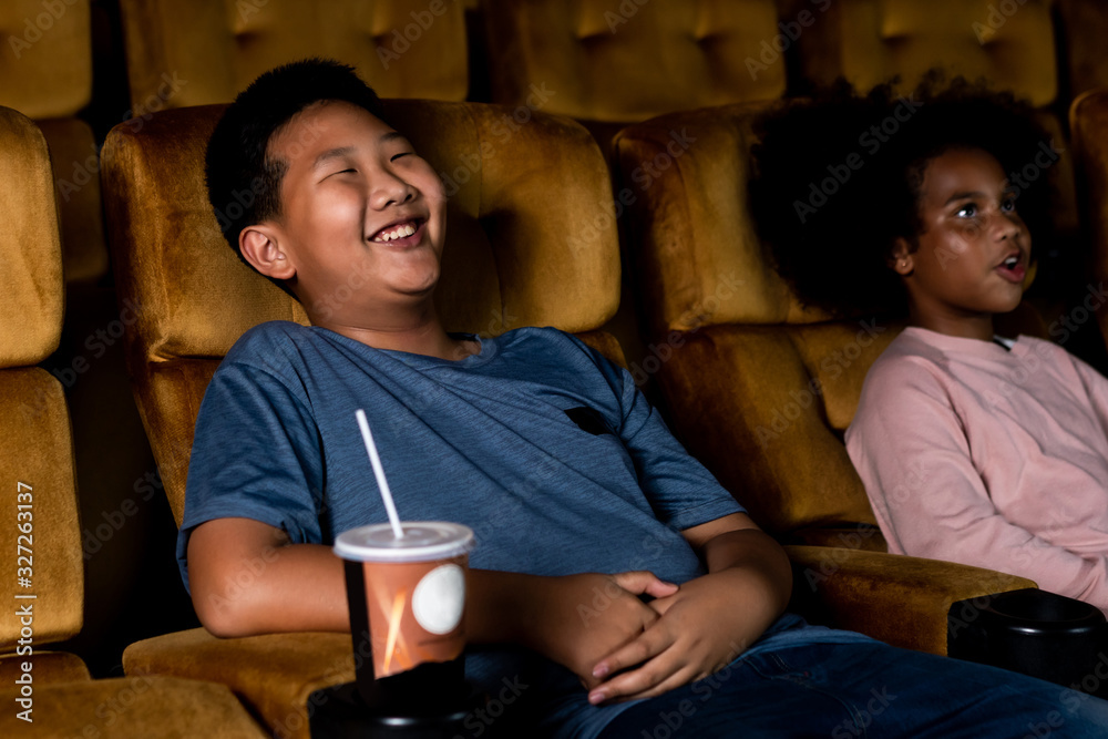 三个孩子在电影院玩得很开心，喜欢看电影