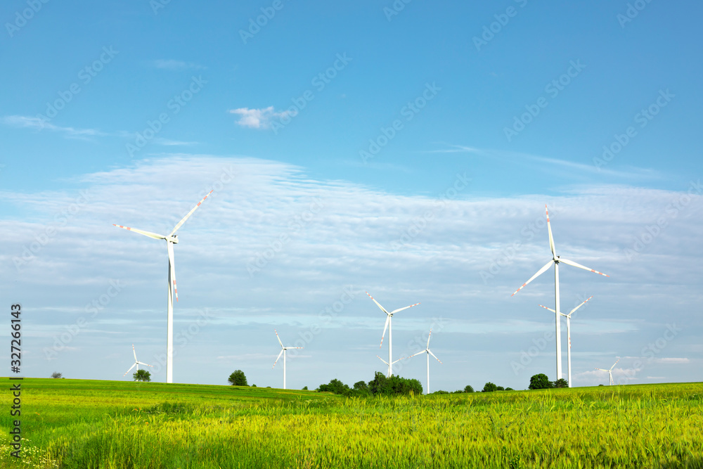 绿色田野中的风力涡轮机，蓝天下的农村地区