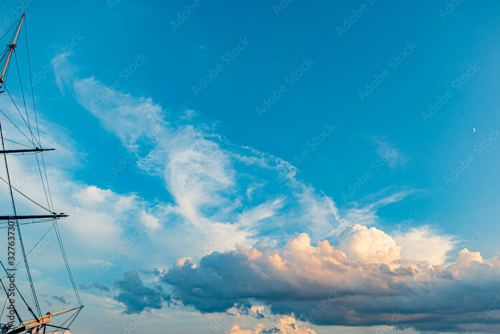 White, orange and dark clouds with blue sky on the sunset summer background