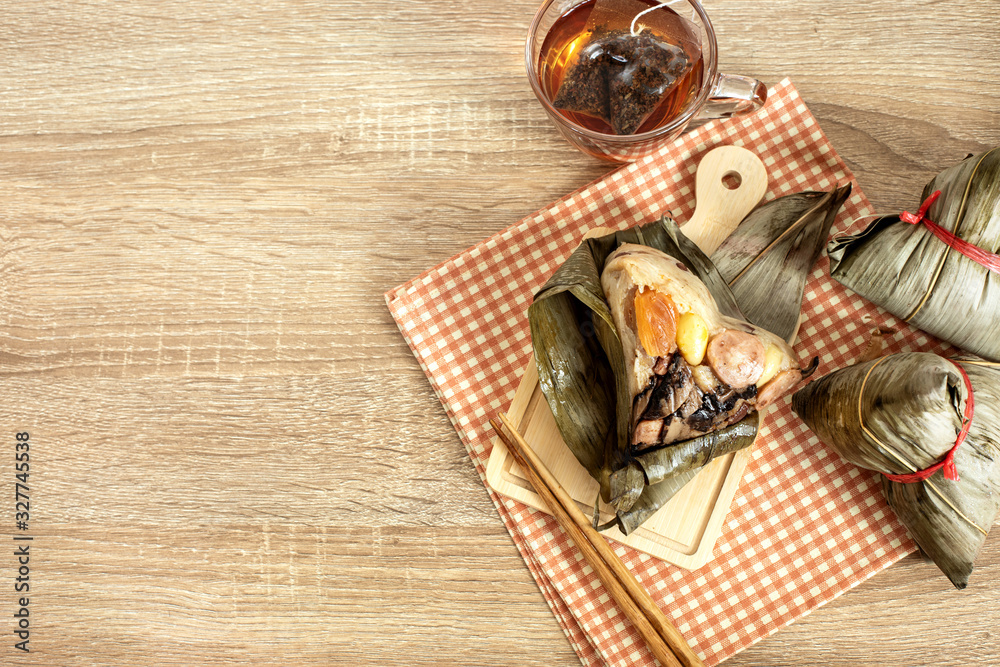 Close up Zongzi or rice dumpling on the wooden table with Chinese tea in Dragon Boat Festival, Asian