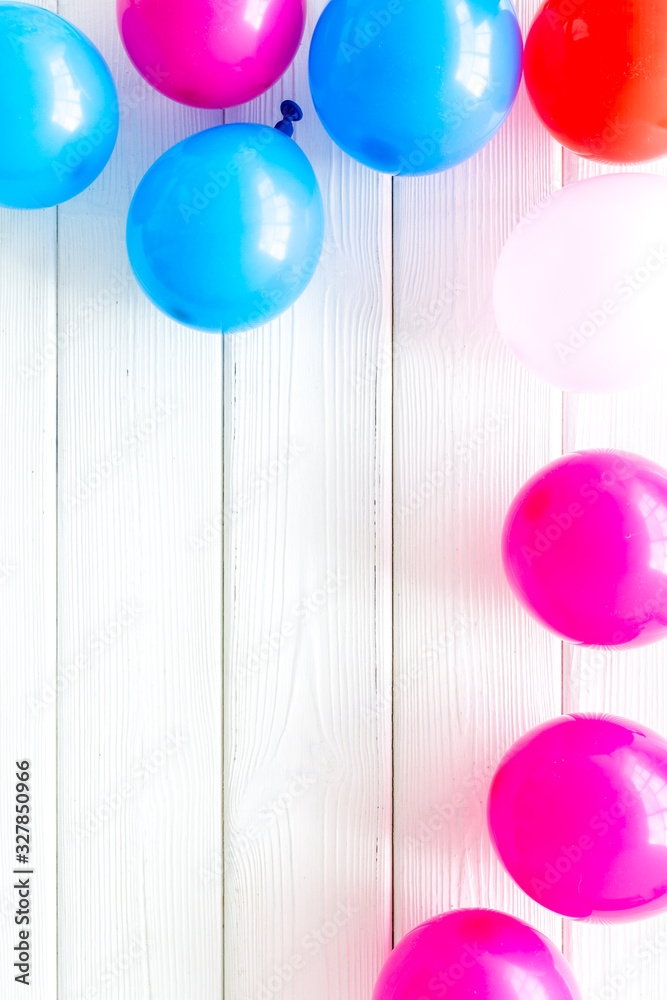 Decorative frame with colorful balloons on white wooden background top-down frame copy space
