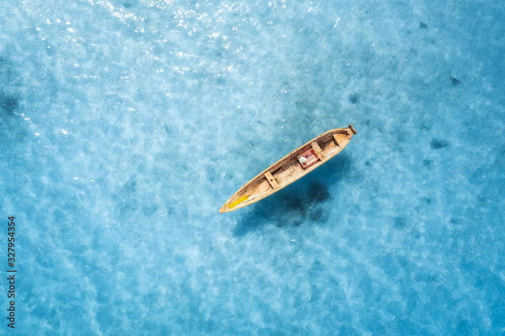 夏天阳光明媚的日子，透明蓝色水中的渔船鸟瞰图。从abov俯瞰