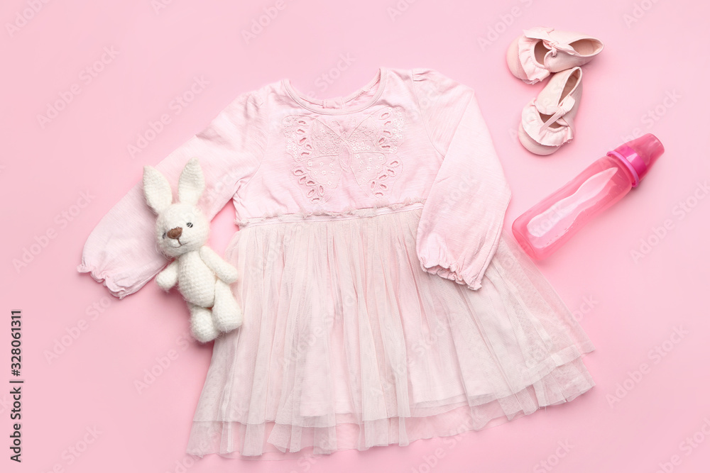 彩色背景带玩具、短靴和瓶子的婴儿服装