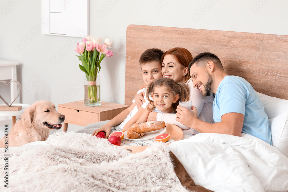 幸福的一家人在家里的卧室里吃早餐