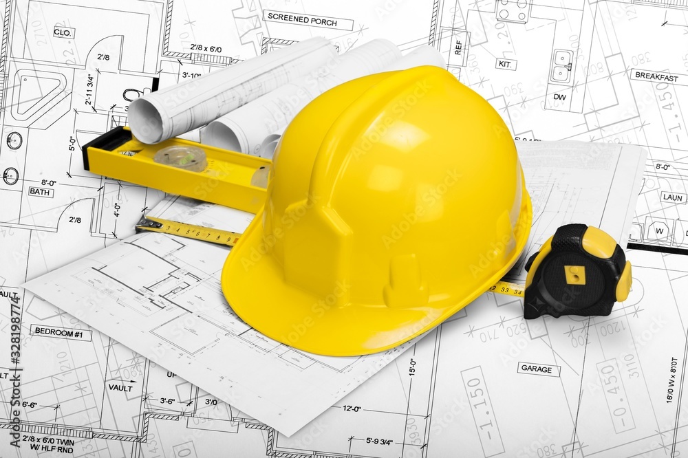 工人头盔和绘制建筑或施工蓝图