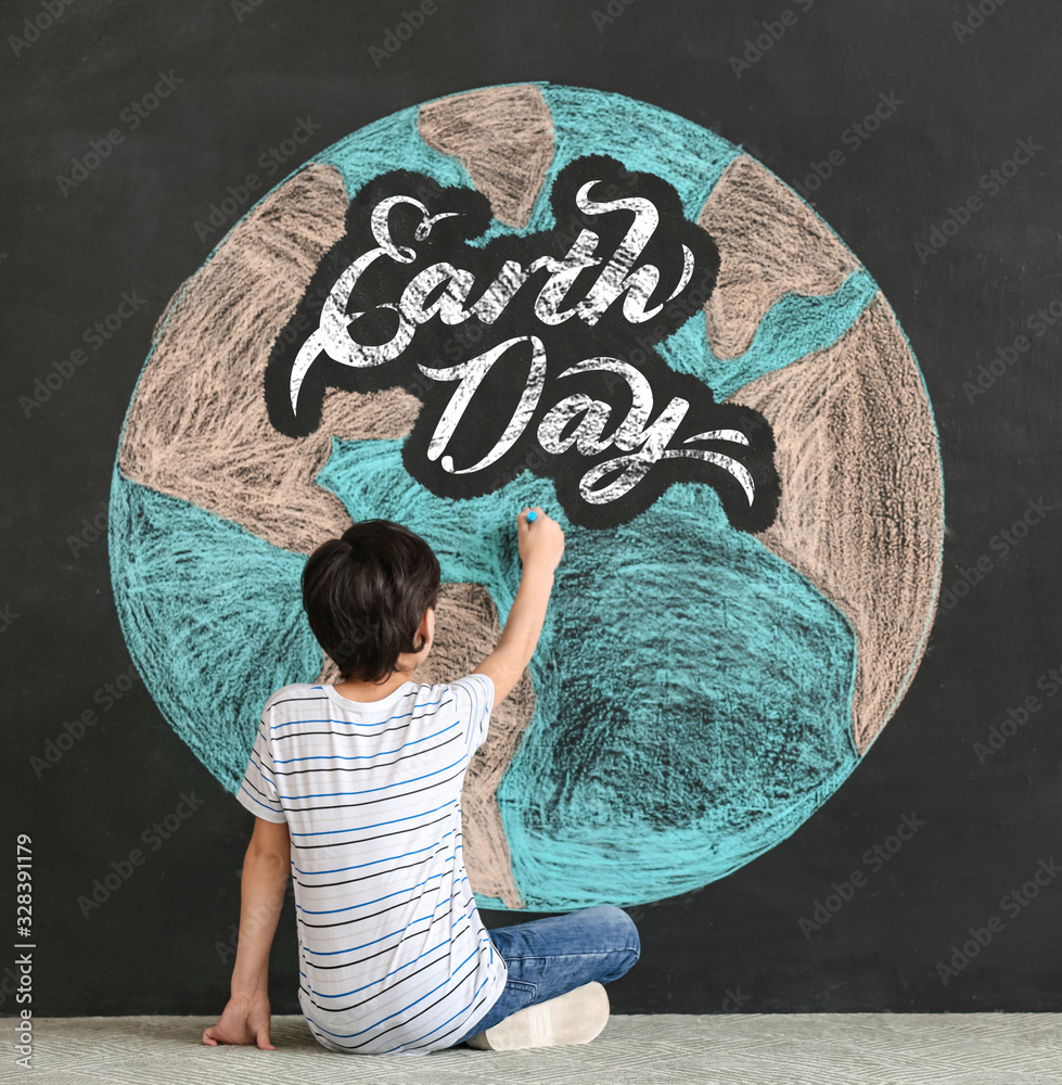 小男孩在黑暗背景下绘制地球。地球日庆祝活动