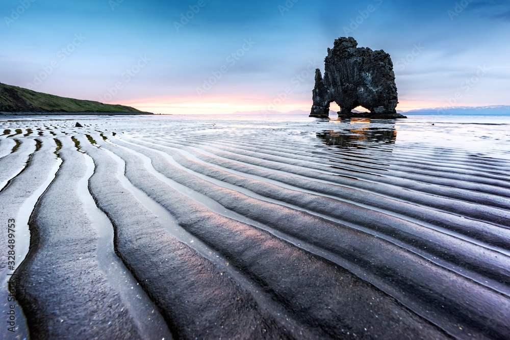 壮丽的日落景观，有著名的Hvitserkur岩石和潮汐后的深色波浪沙。Vatnsnes pe