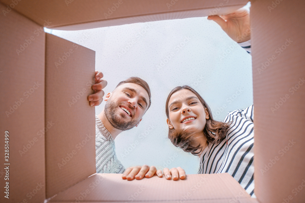 年轻夫妇在纸板箱里看，仰视图