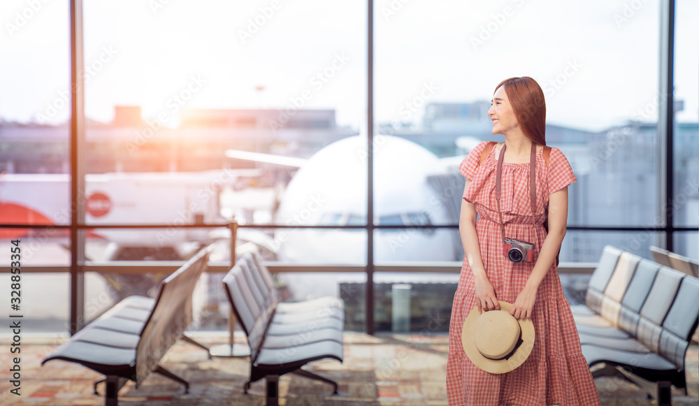 带着行李站在机场窗口看日落的旅游游客
