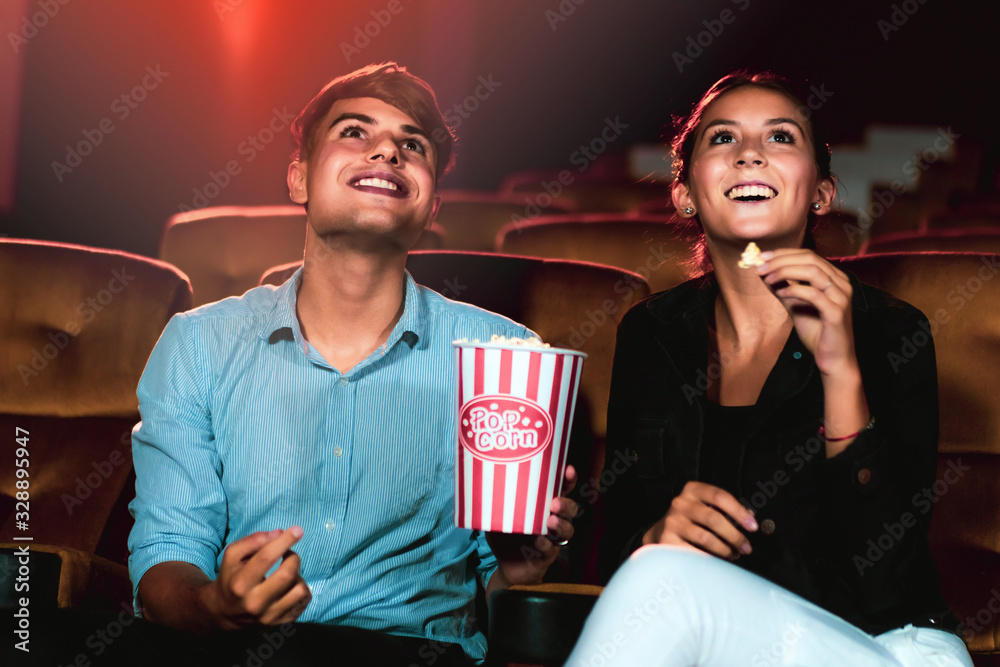 Man and woman watching movie in the movie theater cinema. Group recreation activity and entertainmen