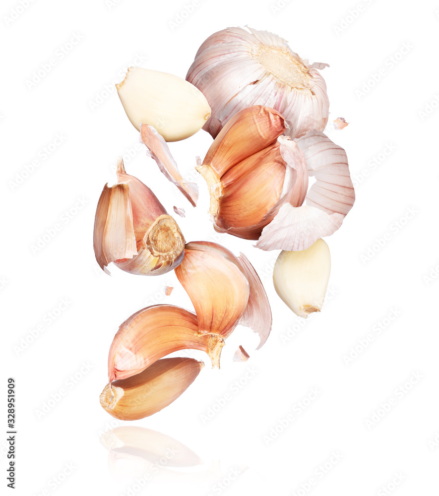 Garlic unfolds in the air close-up, isolated on white background