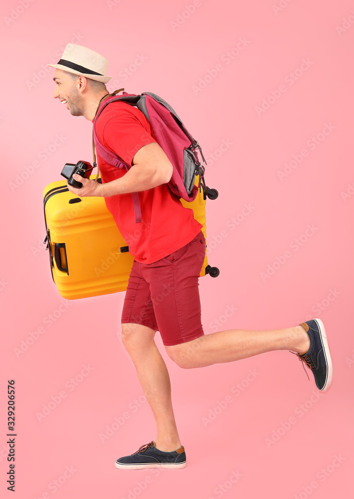 带着彩色背景行李的跑步男游客