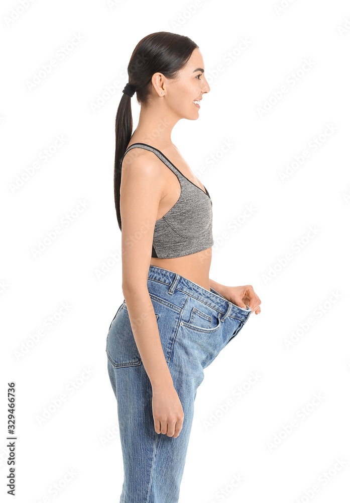 Young woman in loose clothes on white background. Weight loss concept