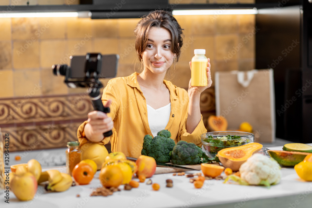 年轻开朗的女性在手机上发布关于健康食品和烹饪的视频记录。健康的概念
