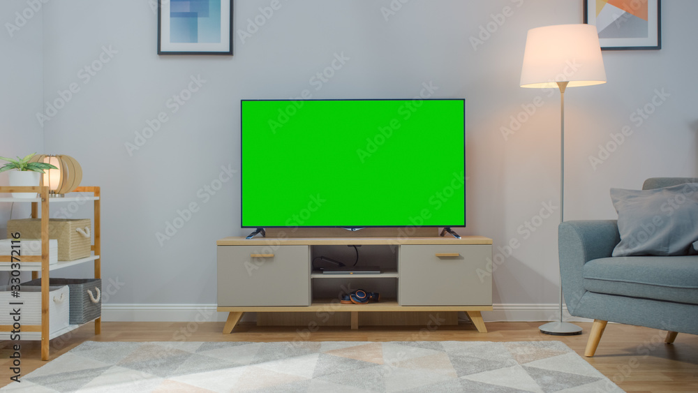带水平绿屏实物模型的电视镜头。白天舒适的客厅，带椅子和拉姆