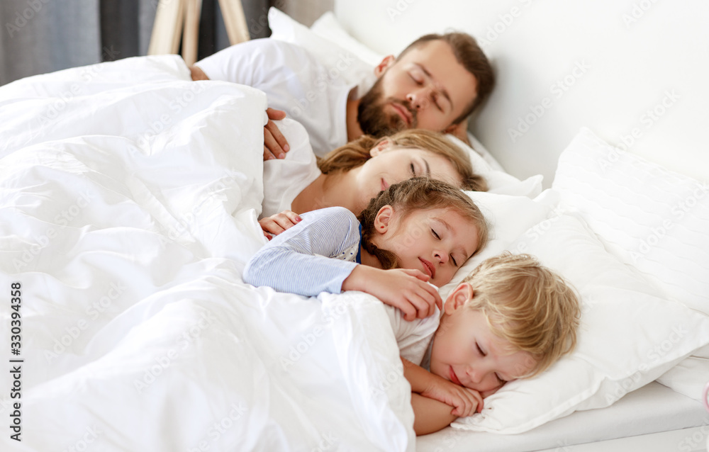 healthy sleep. happy family parents and children sleeping in white bed  .