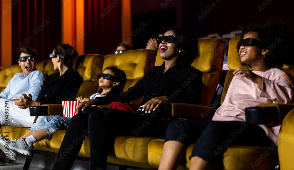 Group of people watch movie with 3D glasses in cinema theater with interest looking at the screen, e