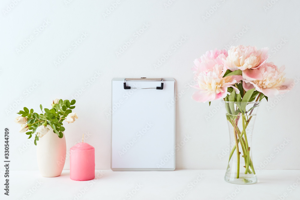 Mockup with a mockup clipboard and pink peonies in a vase on a white background