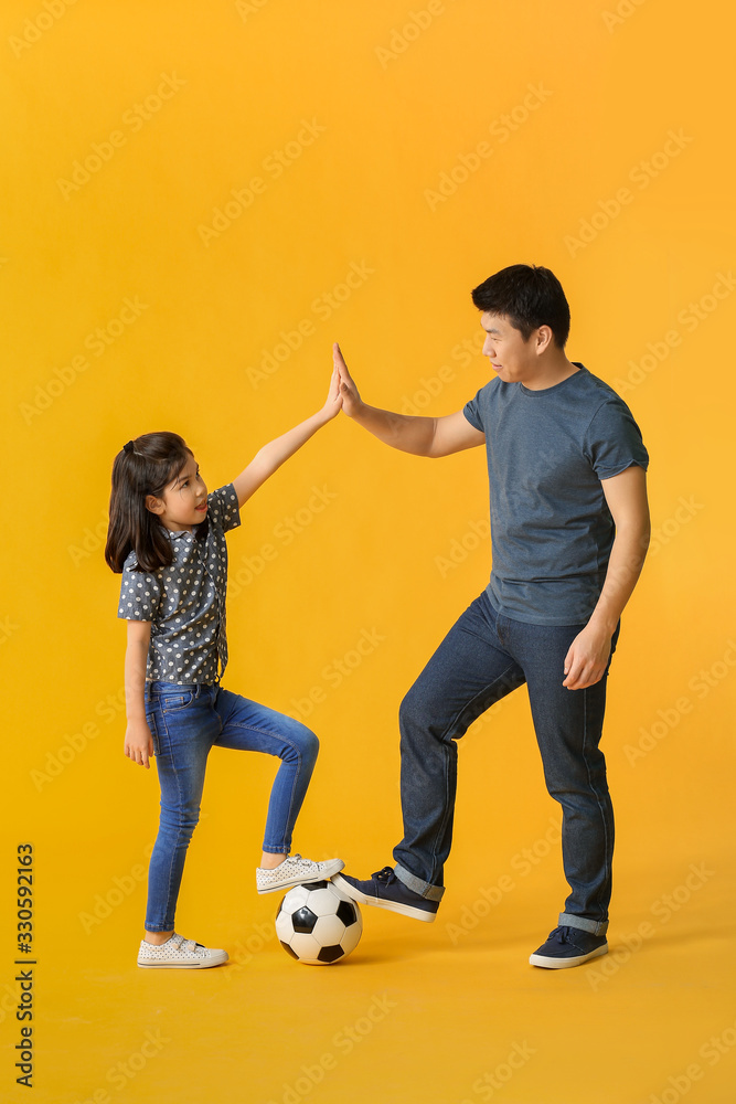 快乐的亚洲男人和他的小女儿，彩球背景