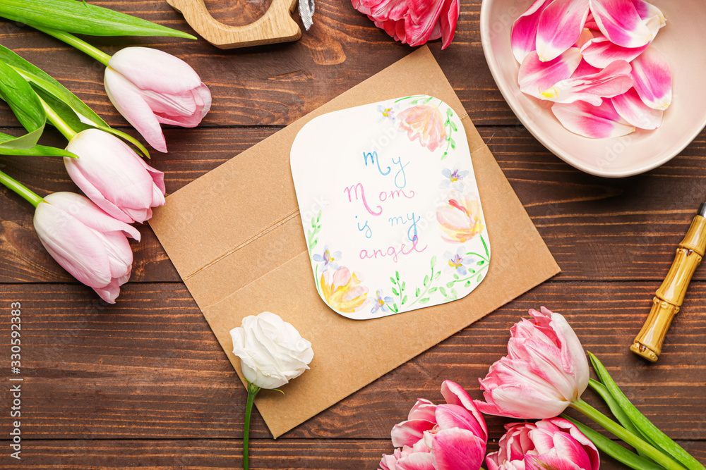 Composition with greeting card for mother on wooden background