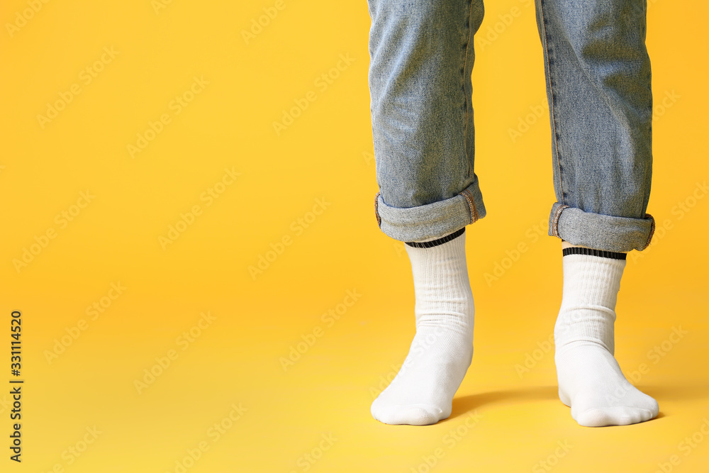 男腿穿着彩色背景的袜子和牛仔裤
